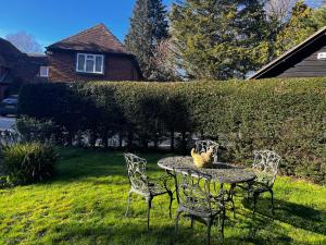 a table with four chairs and a vase on it at Hidden cottage in Abingdon