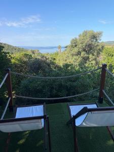 a balcony with two chairs and a view of the ocean at Villa Rosette Ile du levant in Hyères +7 photos