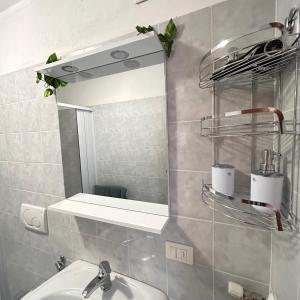 a bathroom with a sink and a mirror at Foresteria Kiki in Gravedona