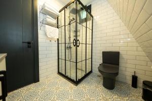 a bathroom with a toilet and a glass shower at Begonvil Gümüşlük in Gümüşlük +7 photos