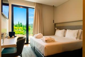 a bedroom with a bed with a desk and a window at Hotel Mezio National Park in Soajo +52 photos