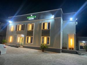 a white building with a sign on it at night at Adwels Hotel&Suites in Akure