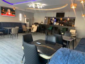 a restaurant with tables and chairs and a bar at Adwels Hotel&Suites in Akure