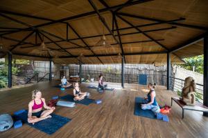 a group of people doing yoga in a tent at Anahata Retreat Beach Front Resort in Mandrem