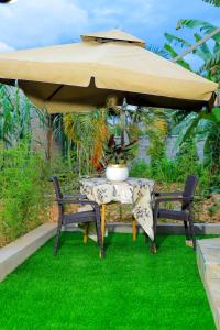 a table and two chairs under a large umbrella at Cozy haven in Kampala