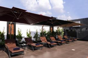 a row of chairs and umbrellas on a patio at BON Hotel Kabuwol in Ibadan