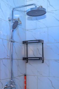 a shower with a shower head on a wall at Cozy haven in Kampala