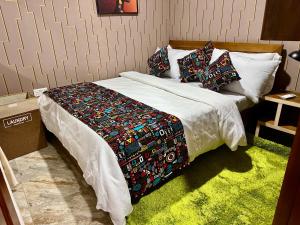 a bed with a blanket and pillows on it at Cozy haven in Kampala +10 photos