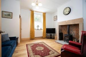 a living room with a couch and a fireplace at 2 Bedroom Cottage By Cozy Quarters Property Management Holiday Lets Wolsingham Near River Waskerley in Wolsingham