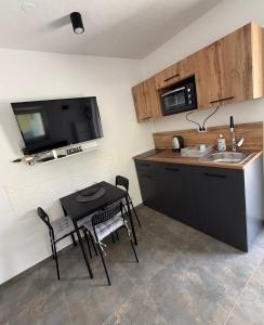 a kitchen with a black table and a sink and a microwave at Apartment Zart 1 in Dekani