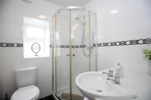 a bathroom with a shower and a sink and a toilet at 2 Bedroom Cottage By Cozy Quarters Property Management Holiday Lets Wolsingham Near River Waskerley in Wolsingham +17 photos