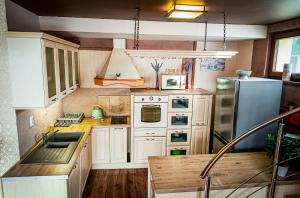 a kitchen with white cabinets and a stainless steel refrigerator at Apartments Sofia - Luxury Penthouse in Liptovský Mikuláš