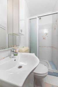 a bathroom with a white sink and a toilet at Studio apartman Lea in Baška