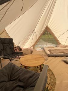 a tent with a table and a chair and a wooden table at Wiesn-Relax-Camping in Ranten +15 photos