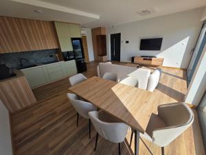 a kitchen and dining room with a wooden table and chairs at Widokowa Dąbrowa in Dąbrowa