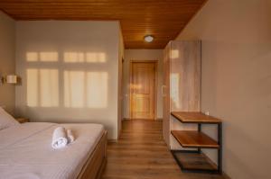 a bedroom with a bed and a table and a door at Hotel Babuda in Mestia in Mestia
