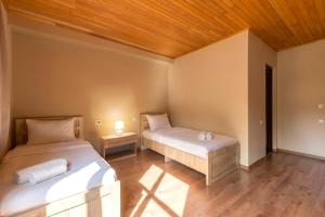a bedroom with two beds and a wooden ceiling at Hotel Babuda in Mestia in Mestia