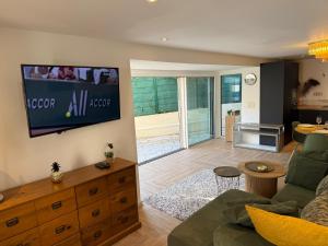 a living room with a couch and a tv on the wall at CANNES Maison Design "DOLCE VITA" in Cannes
