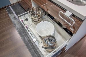 a kitchen counter with dishes and a fan on a stove at メリエイト三崎通 in Kuwana +34 photos