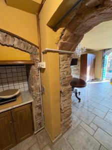 a kitchen with a stone wall and a table in a room at Le Soleil in Casale Marittimo