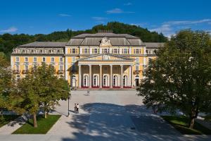 un grande edificio giallo con alberi di fronte di Grand Hotel Rogaška Premium a Rogaška Slatina