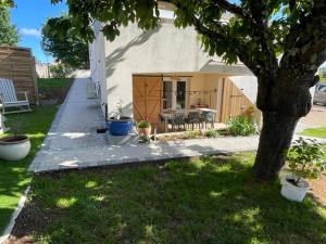 a house with a tree in the yard at À la clef des champs in Chauray
