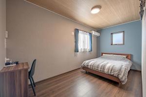 a bedroom with a bed and a desk and a window at メリエイト三崎通 in Kuwana