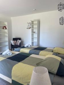 a room with three beds and a chair at La Chouette du Freyr 3 chambres in Dinant