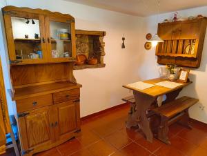 a kitchen with a wooden cabinet and a table at Casa da Torre in Sao Pedro de Tomar