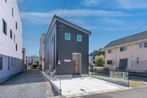 a black building with a door on a street at メリエイト三崎通 in Kuwana