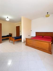 a large bedroom with two beds with red sheets at Hotel Garden Albania in Golem