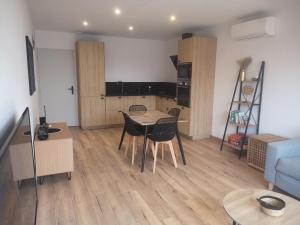 a living room with a table and chairs and a couch at Escapade Bassin - Spa Privé - Maison 6 Pers in Audenge