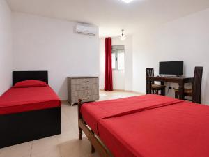 a bedroom with two beds and a desk with a computer at Hotel Garden Albania in Golem