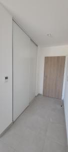 an empty room with white walls and a wooden door at L'Appar-TMN in Challans +4 photos