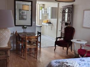 a living room with a table and chairs and a kitchen at Studio chez Jef in Nuits-Saint-Georges
