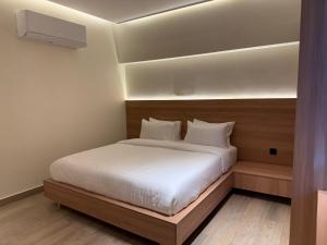 a bedroom with a bed with white sheets at Hamsun DHA in Karachi