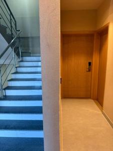 a hallway with stairs and a door in a building at Hamsun DHA in Karachi
