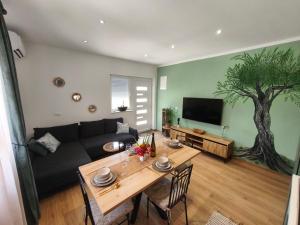 a living room with a couch and a table at Olive Tree Apartment in Kaštela