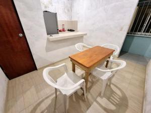 a wooden table and two white chairs in a room at Casa Mayan in La Vigueta +2 photos
