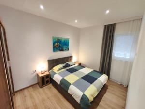 a bedroom with a bed and two lights on at Olive Tree Apartment in Kaštela
