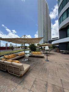 a patio with couches and umbrellas in a city at Flat Parque do Cais in Recife By Flatbpaiva in Recife