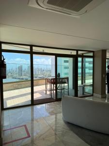 a room with glass doors and a table with a view at Flat Parque do Cais in Recife By Flatbpaiva in Recife