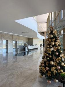 a christmas tree in the middle of a lobby at Flat Parque do Cais in Recife By Flatbpaiva in Recife +51 photos