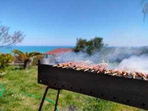 a row of meat on a grill with smoke at B&B Emilia's House in Roseto degli Abruzzi