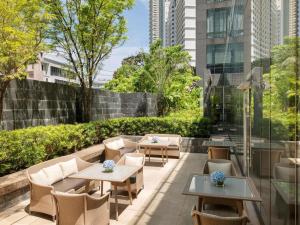 a patio with tables and chairs in a building at Raffles Makati in Manila