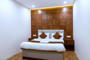 a bedroom with a bed with a wooden wall at Hotel Velvet Dreams Inn & Banquet in Kharar
