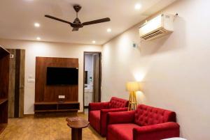 a living room with two red couches and a flat screen tv at Hotel Velvet Dreams Inn & Banquet in Kharar