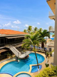 a resort pool with a slide and palm trees at Paradise Jaco Beach Front in Jacó