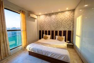 a bedroom with a bed and a large window at Hotel Velvet Dreams Inn & Banquet in Kharar +34 photos