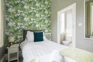 a bedroom with a bed with a green and white wallpaper at The Capsule Room at The Lairbeck in Keswick in Keswick +3 photos